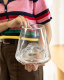 Vaso decorativo Malva em Murano transparente com montanha esculpida no fundo, segurado nas mãos