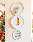 Composição de parede com os pratos decorativos Golden nas Alturas em porcelana ao lado de árvore de Natal