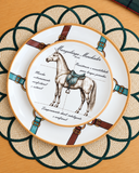 Prato de sobremesa de cerâmica Haras em formato coup, branco com ilustração de cavalo Mangalarga Marchador de sela verde e filete laranja, com o prato raso Haras ao fundo.