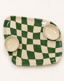 Petisqueira de cerâmica Oval Chess em xadrez verde e off-white com duas cumbucas, em vista aproximada que mostra o contorno orgânico da peça.