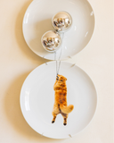 Kit com 2 pratos decorativos de porcelana branca formando cena de golden retriever voando com balões prateados